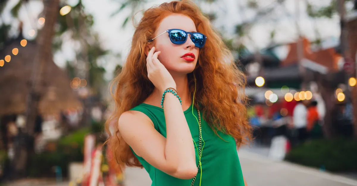 Stylish woman with long red hair wearing sunglasses, red and black hair color ideas inspiration