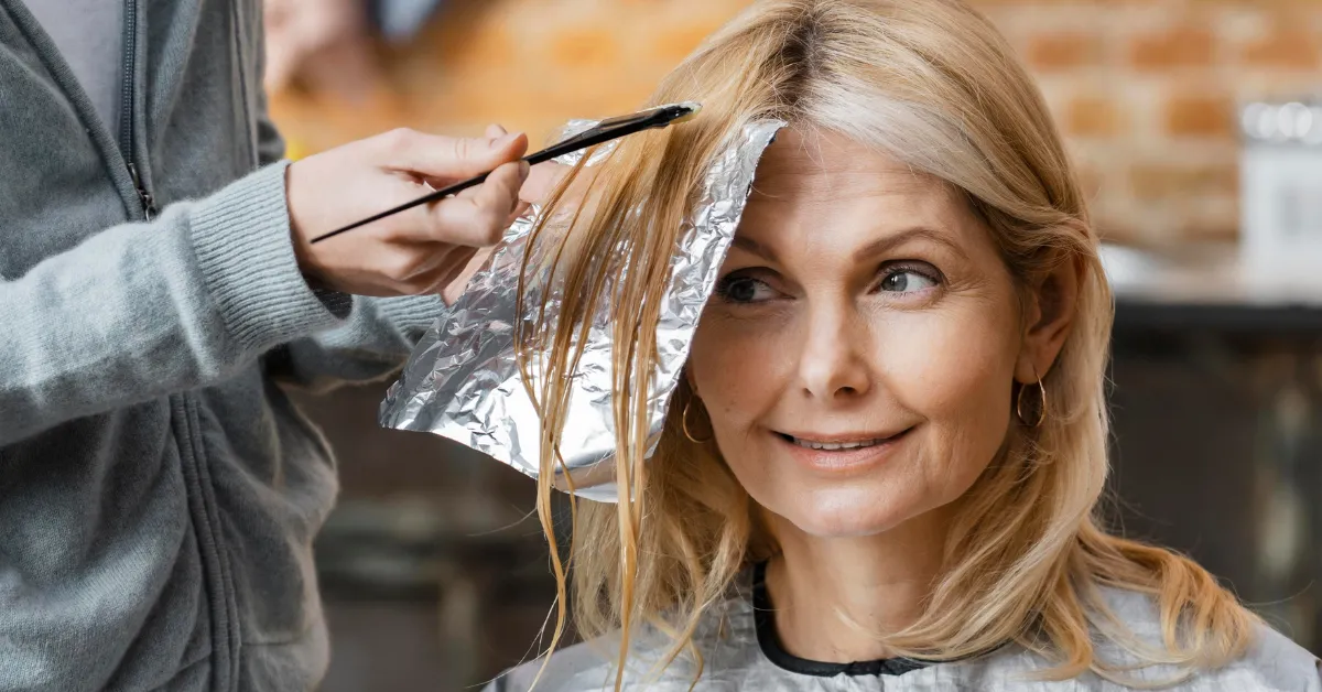 Woman getting highlights at salon, blonde hair color ideas for fresh modern look